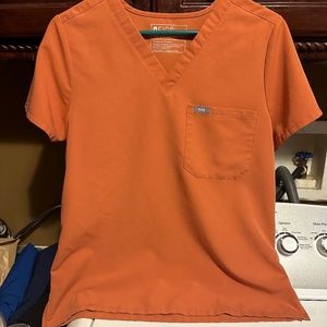 Figs tuck in scrub top-1 pocket